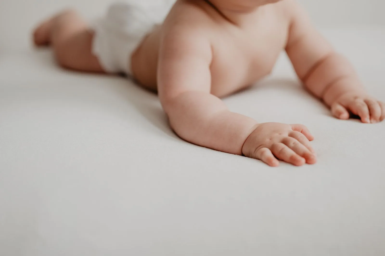 あたたかな光のなかでうつ伏せ遊びをする赤ちゃん（イメージ写真）
